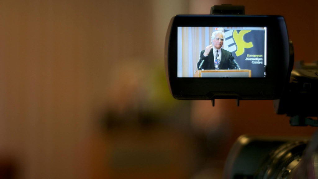 Howard Finberg speaking at the European Journalism Centre, seen through a TV camera viewfinder